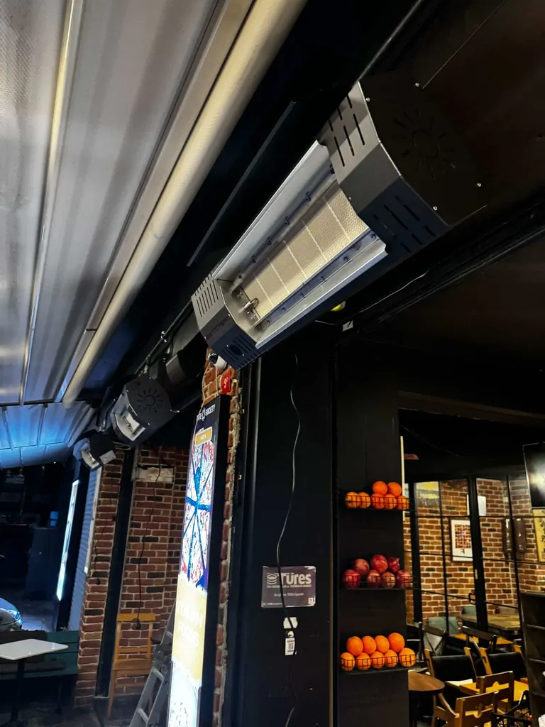 Restoran terasında radyant ısıtıcı, cam cephe ve oturma alanı